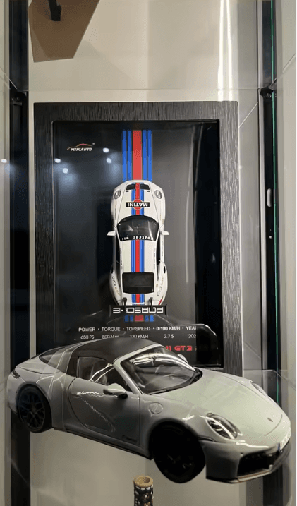 Porsche framed display shown in a glass case